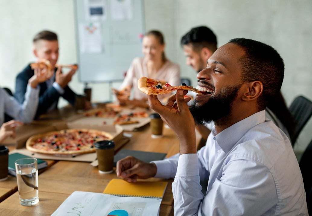 Corporate Lunch Break. Group of Colleagues Eating Takeaway Pizza in Office